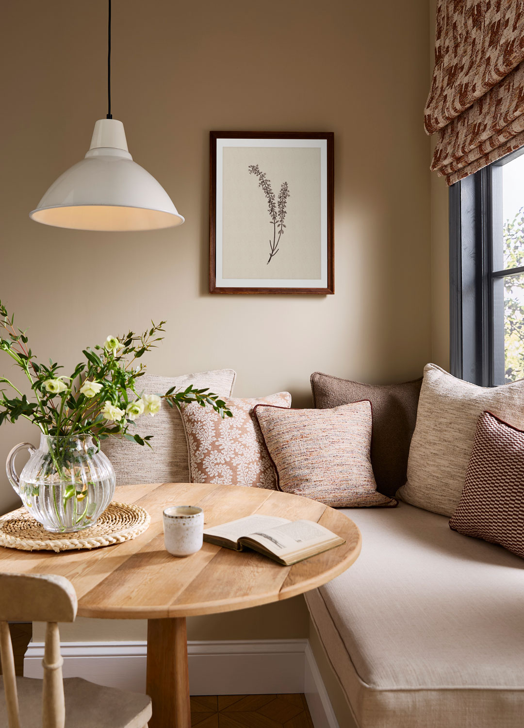 corner banquette seating with upholstered cushion and scatter cushions with round wooden dining table