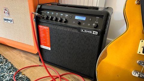 Line 6 Spider 30 next to a Les Paul style guitar