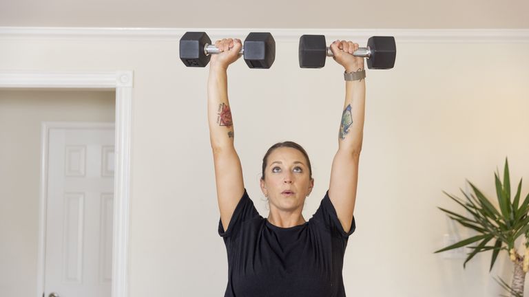 Woman working out with dumbbells at home
