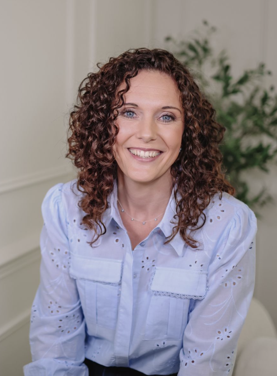 woman with curly hair smiles to camera