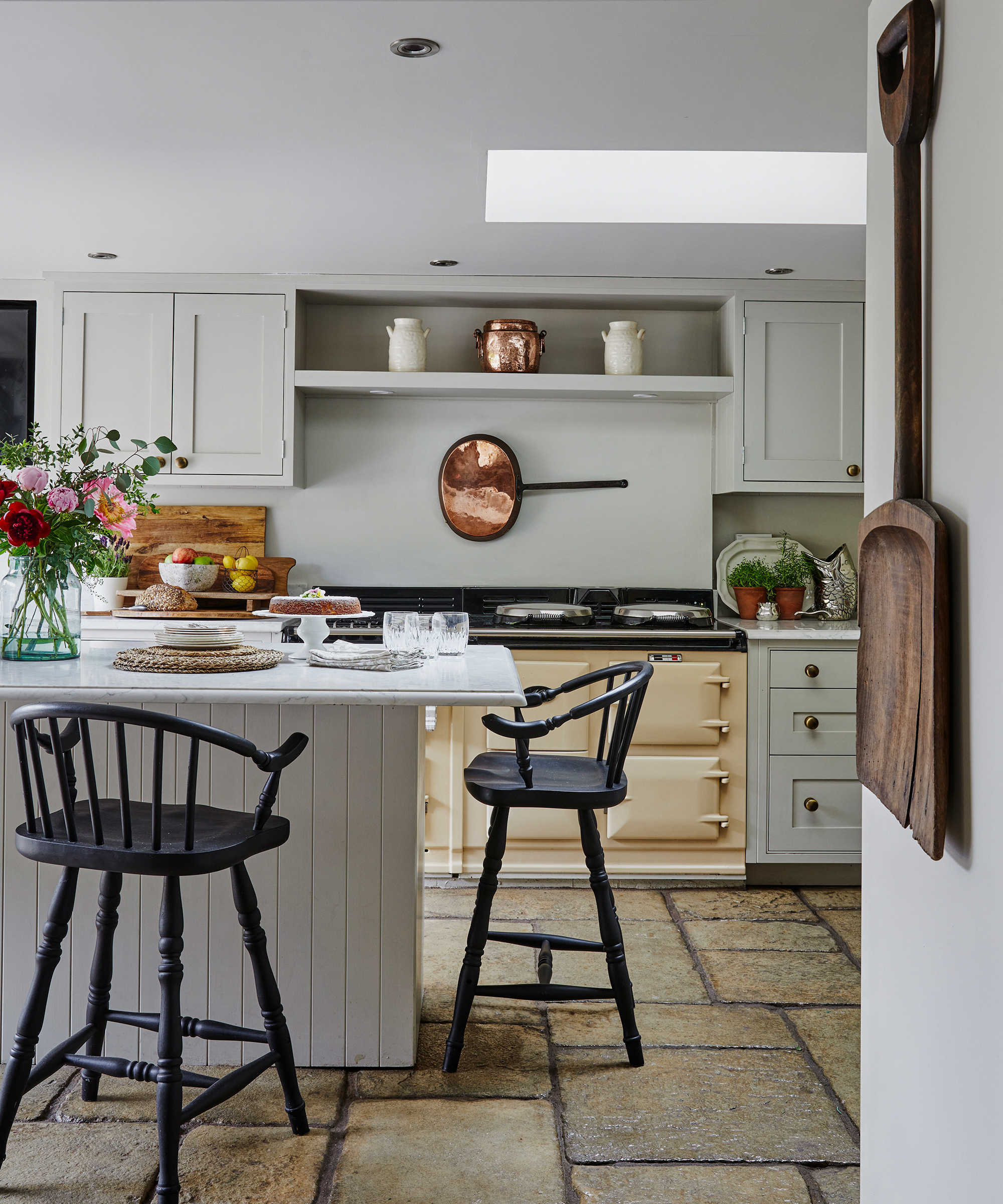 Country-style shaker kitchen with cream Aga, neutral units, island and windsor style bar stools