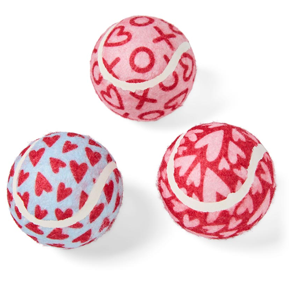 three dog toy balls decorated with hearts