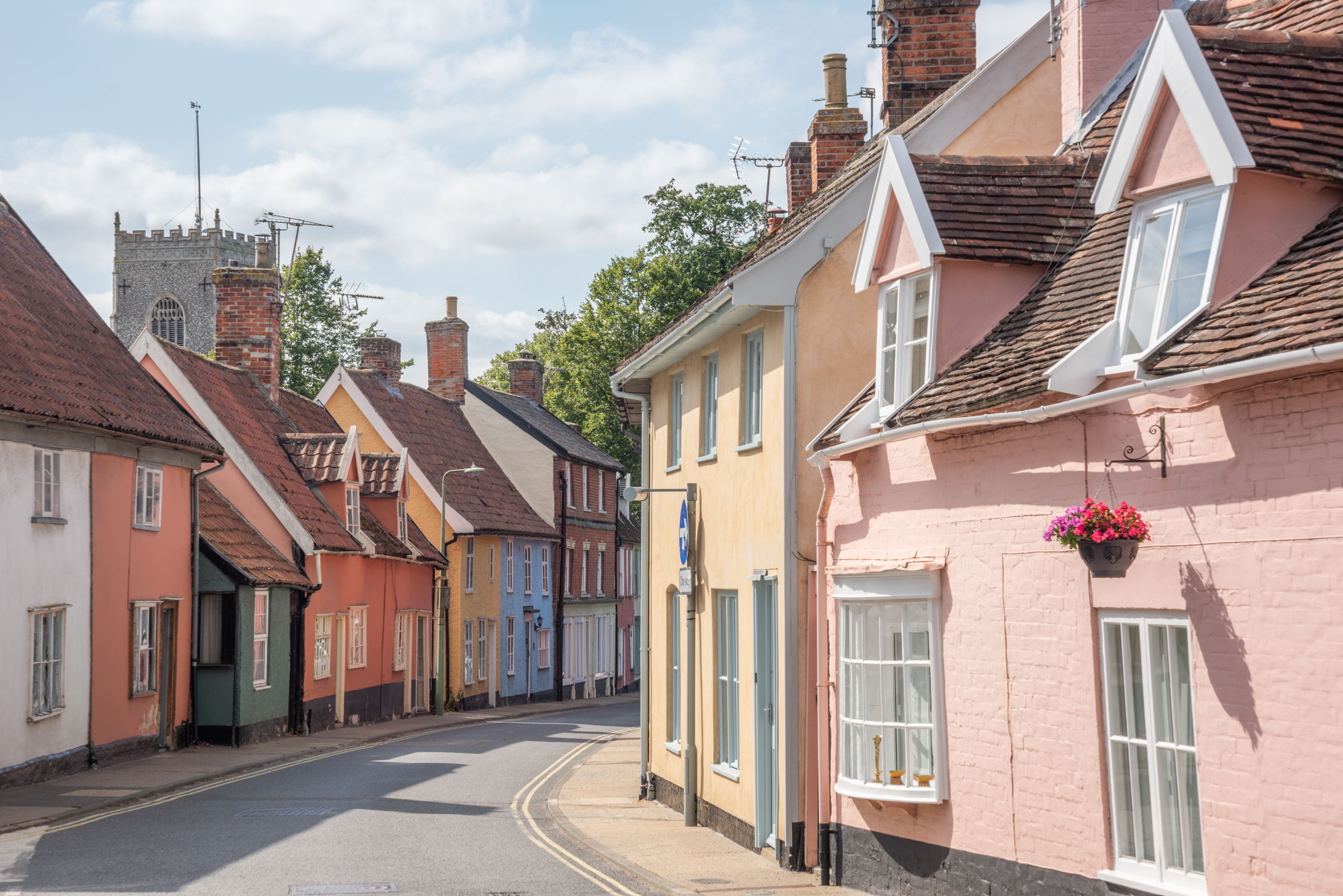 A brightly coloured row of houses on the high street of a town in suffolk
