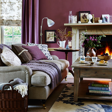 living room with magenta walls sofa set with cushions and fireplace