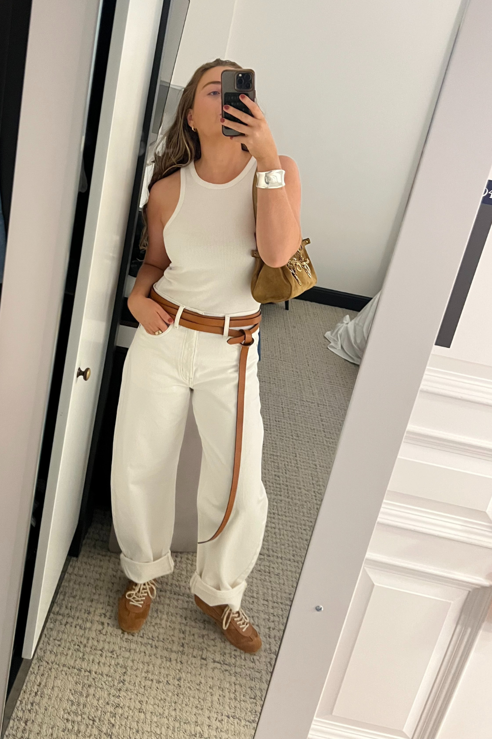 Lauren Cunningham wears brown suede trainers white jeans, white vest
