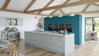 open plan kitchen dinger with green full height units and large pale green kitchen island