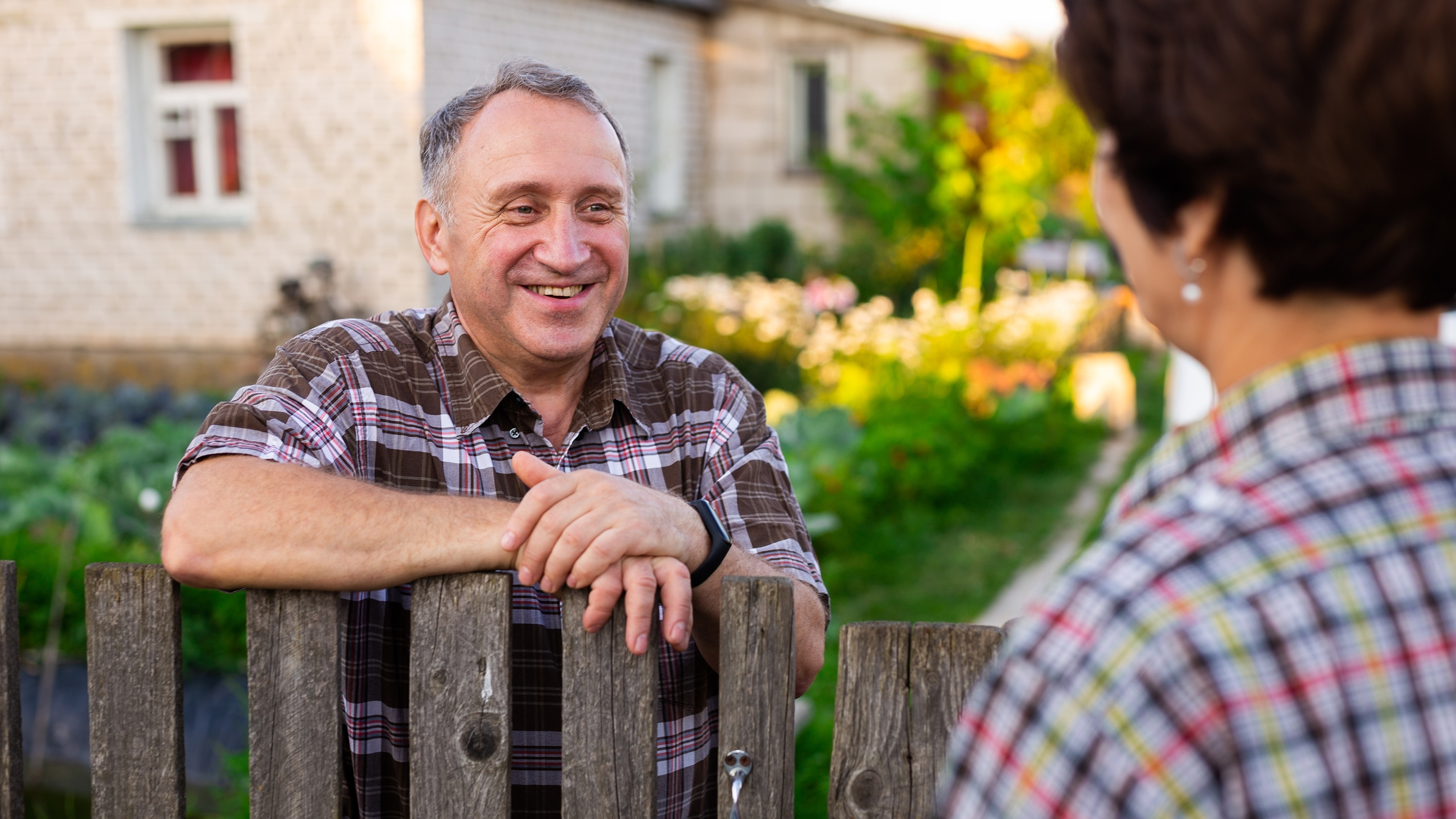 Neighbors speaking over the garden fence