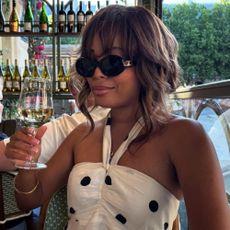 A woman in a French restaurant with a French tip manicure