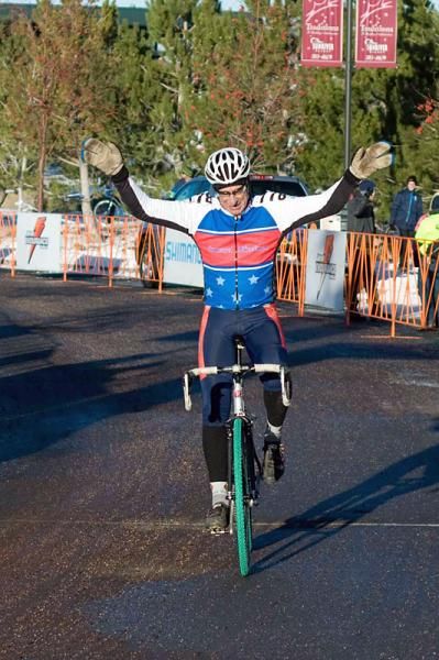 Joe Saling raises his arms as he wins the Master men's 70+ race.