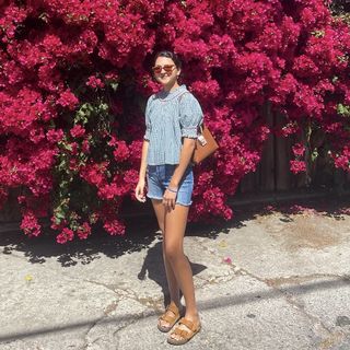 Woman wearing denim shorts and Birkenstocks.