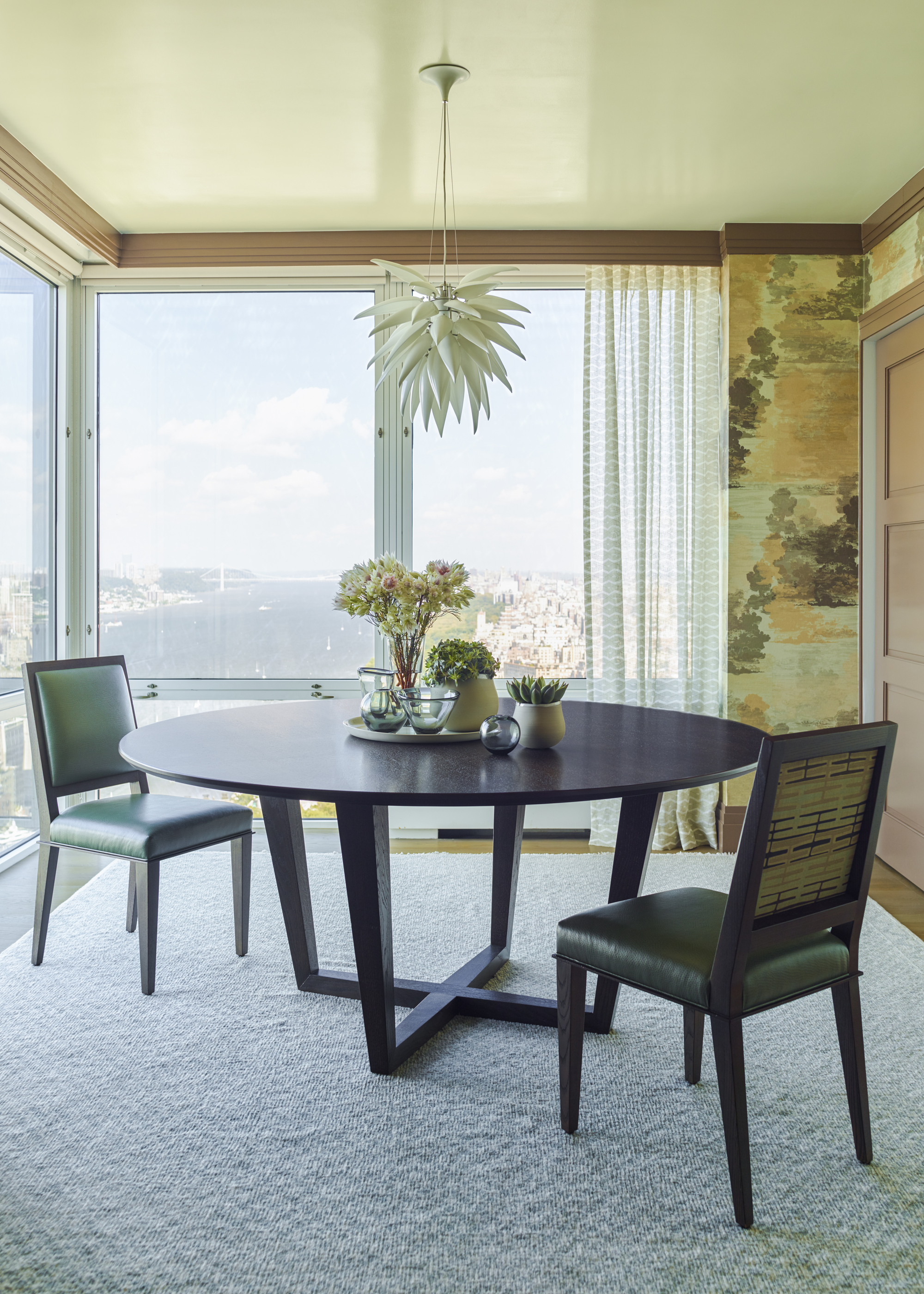 A dining room with a circular table and chairs positioned on the diagonal