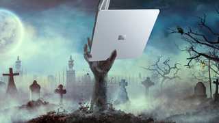 Zombie hand rise from the grave holding a Surface Laptop Go