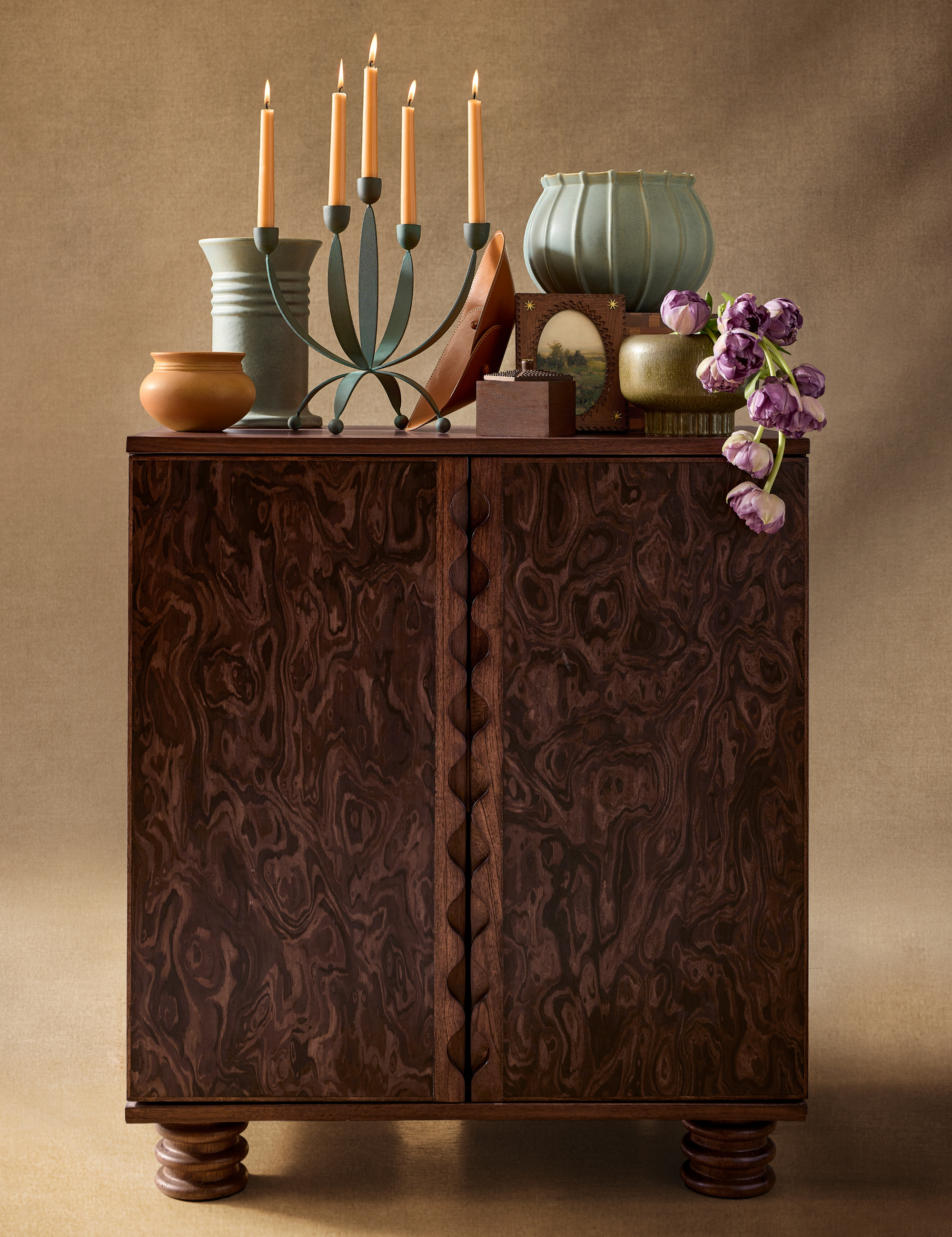 Vintage-inspired burl wood cabinet vignette styled with surrealist dusty blue tabletop ceramics and other accessories