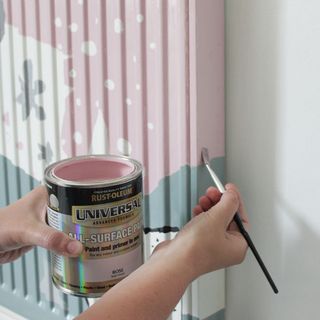 pink paint can and radiator on wall