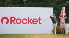 Davis Riley hits a drive in front of a large Rocket sign at the 2026 Rocket Classic