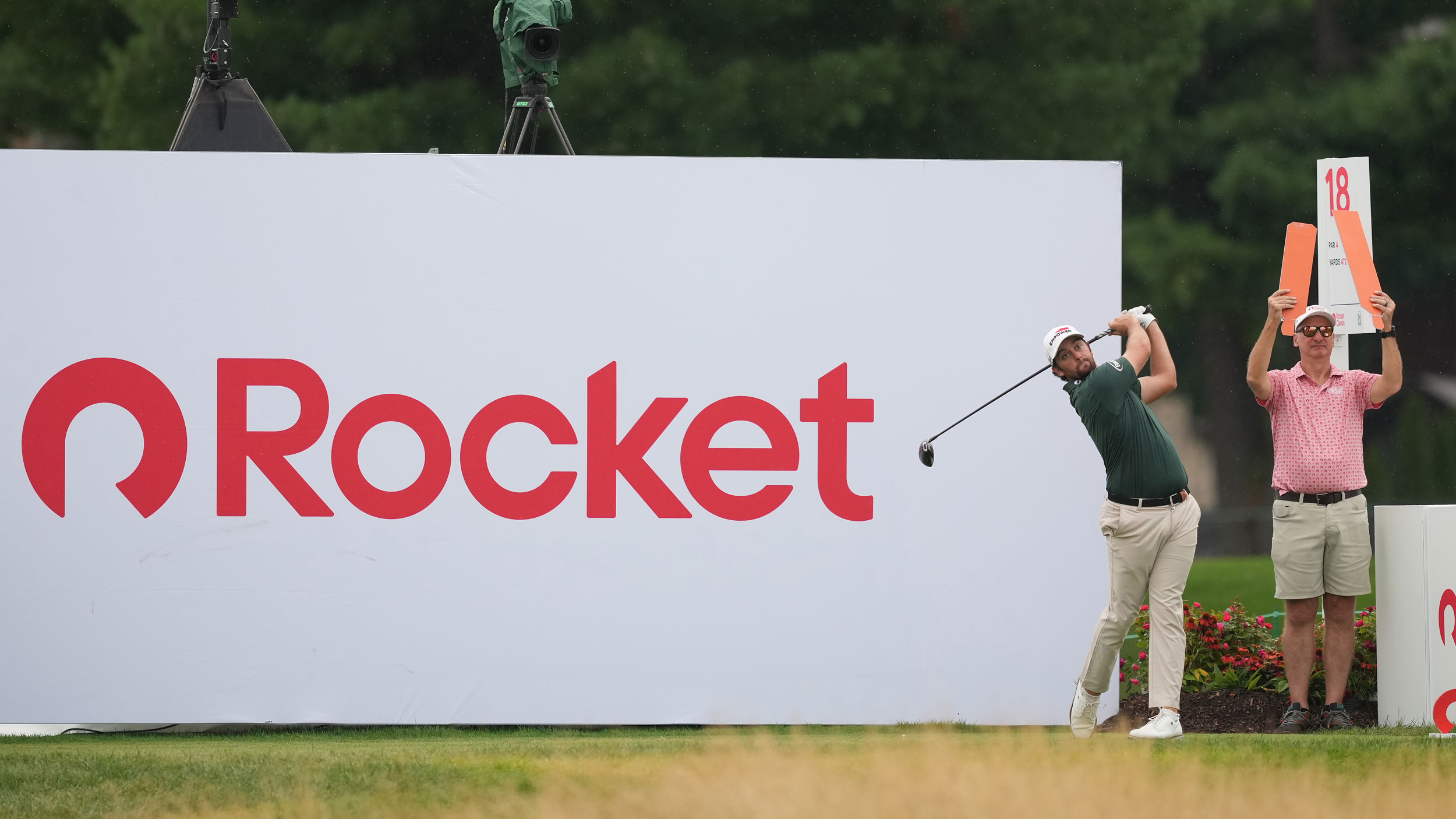 Davis Riley hits a drive in front of a large Rocket sign at the 2026 Rocket Classic