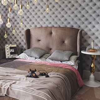 grey velvet hotel style bedroom with oversized headboard