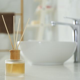a reed diffuser on a white bathroom counter