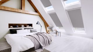a huge white loft conversion bedroom with sky light windows, wooden beams, and blinds by Direct Blinds