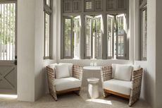 A living room with curtains replaced by shutters