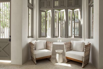 A living room with curtains replaced by shutters