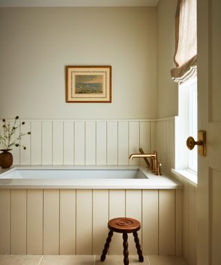 bathroom with cream paneled walls and painting on wall