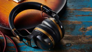 Pair of Vox headphones lying on a guitar