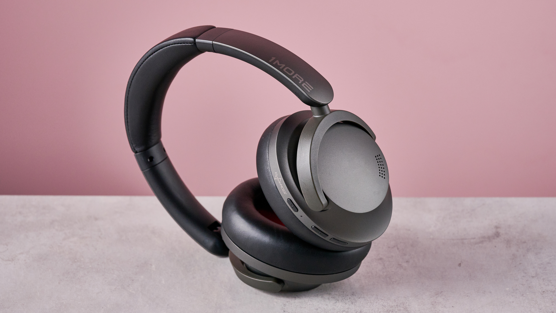 1More SonoFlow Pro HQ51 headphones on a gray surface with a pink background