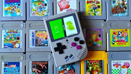 Bittboy retro handheld on top of old Game Boy cartridges 