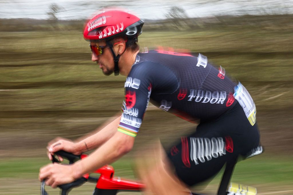 This slow shutter photograph shows Tudor Pro Cycling Team's French rider Julian Alaphilippe cycling during the 1st stage of the Paris-Nice cycling race, 156,1 km between Le Perray-en-Yvelines and Le Perray-en-Yvelines, on March 9, 2025. (Photo by Anne-Christine POUJOULAT / AFP)