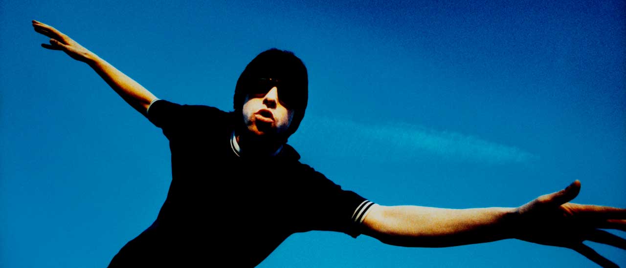 Bobby Gillespie, pictured dancing in front of a bright blue sky