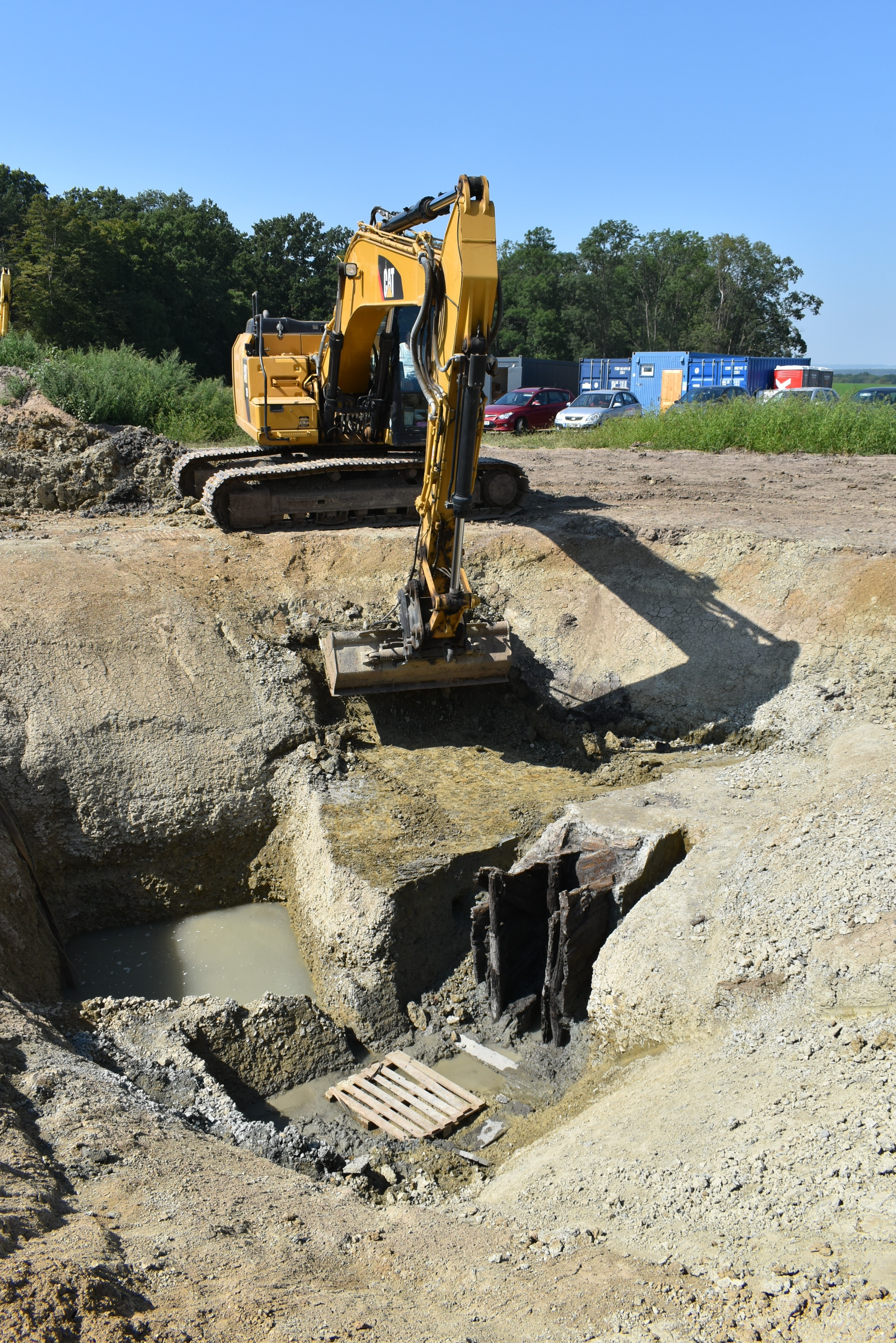Archaeological excavation of celtic settlement; digger removing dirt during excavation.