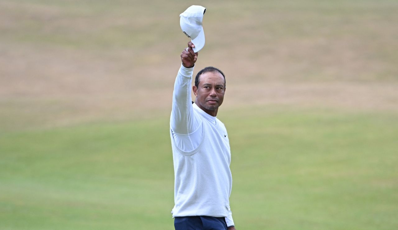 Tiger waves to the crowd on the 18th