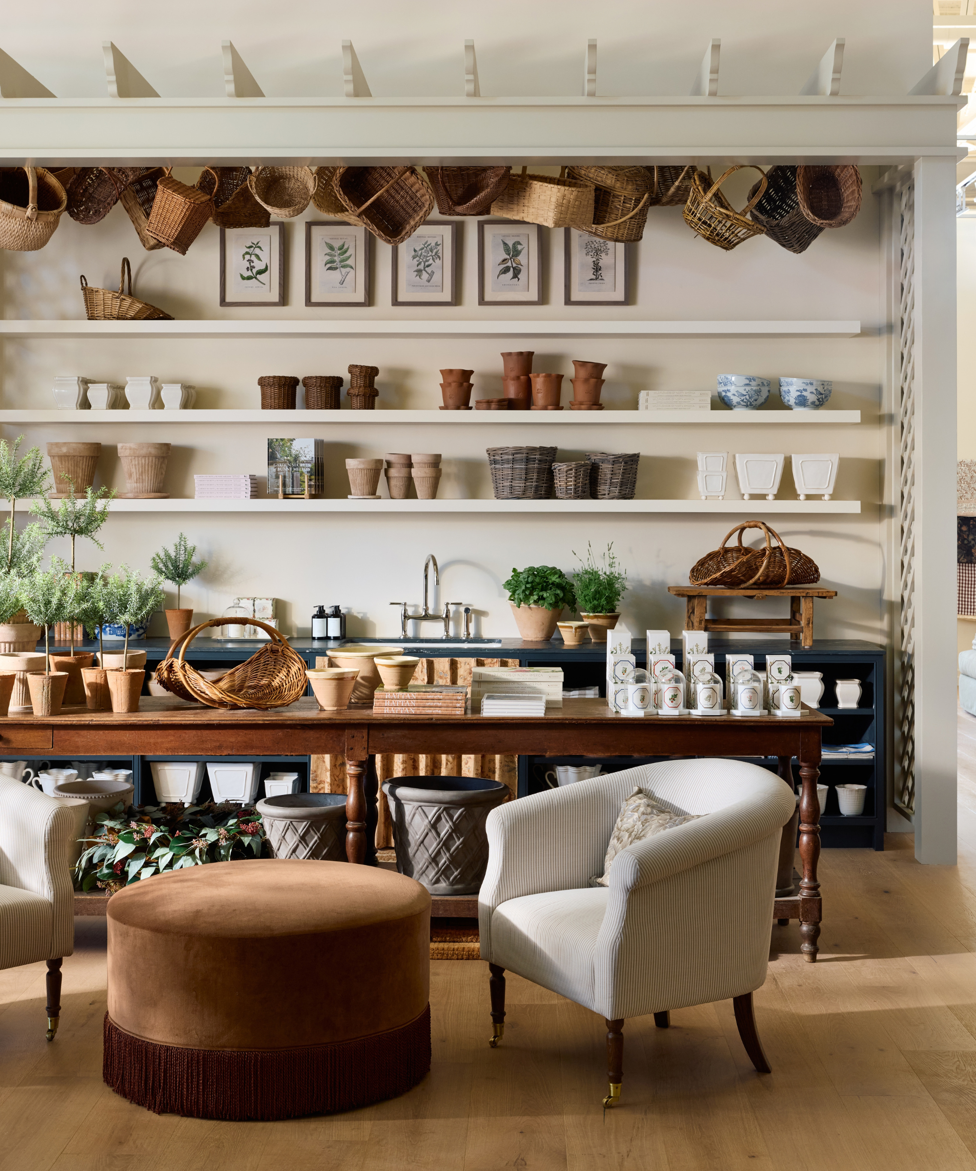 Garden shop area of the new McGee &amp;amp; Co. flagship, featuring shelves of ceramic planters, woven baskets, and antique botanical wall art.