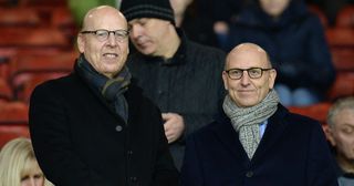 Manchester United co-chairmen Joel Glazer and Avram Glazer (L) prepare to watch the English Premier League football match between Manchester United and Burnley at Old Trafford in Manchester, north west England, on February 11, 2015. Manchester United won the game 3-1.