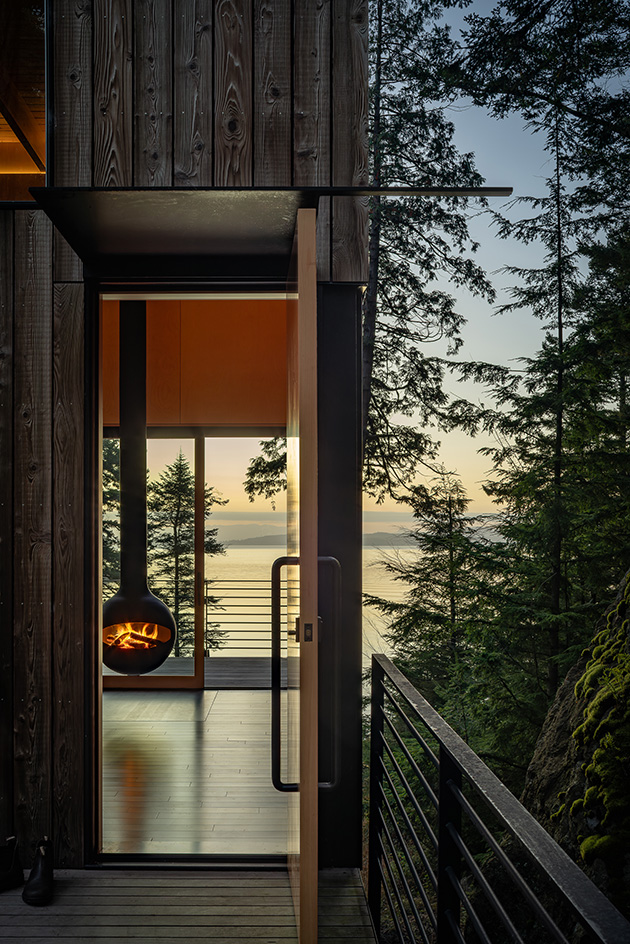 Blakely Island Cabin, a boxy structure raised on stilts above tree canopy in washington state forest