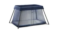 A blue mesh travel cot by BabyBjorn