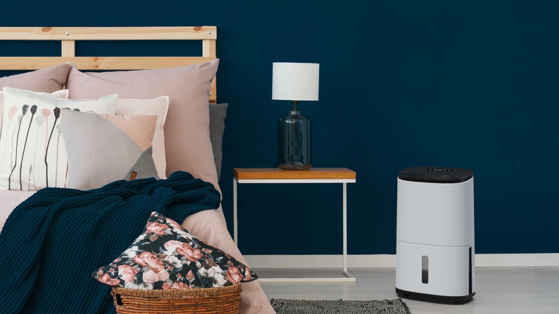 Navy blue bedroom with dehumidifier to suggest how to dry clothes indoors quickly