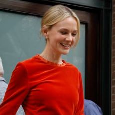Carey Mulligan wears a persimmon colored top and skirt.