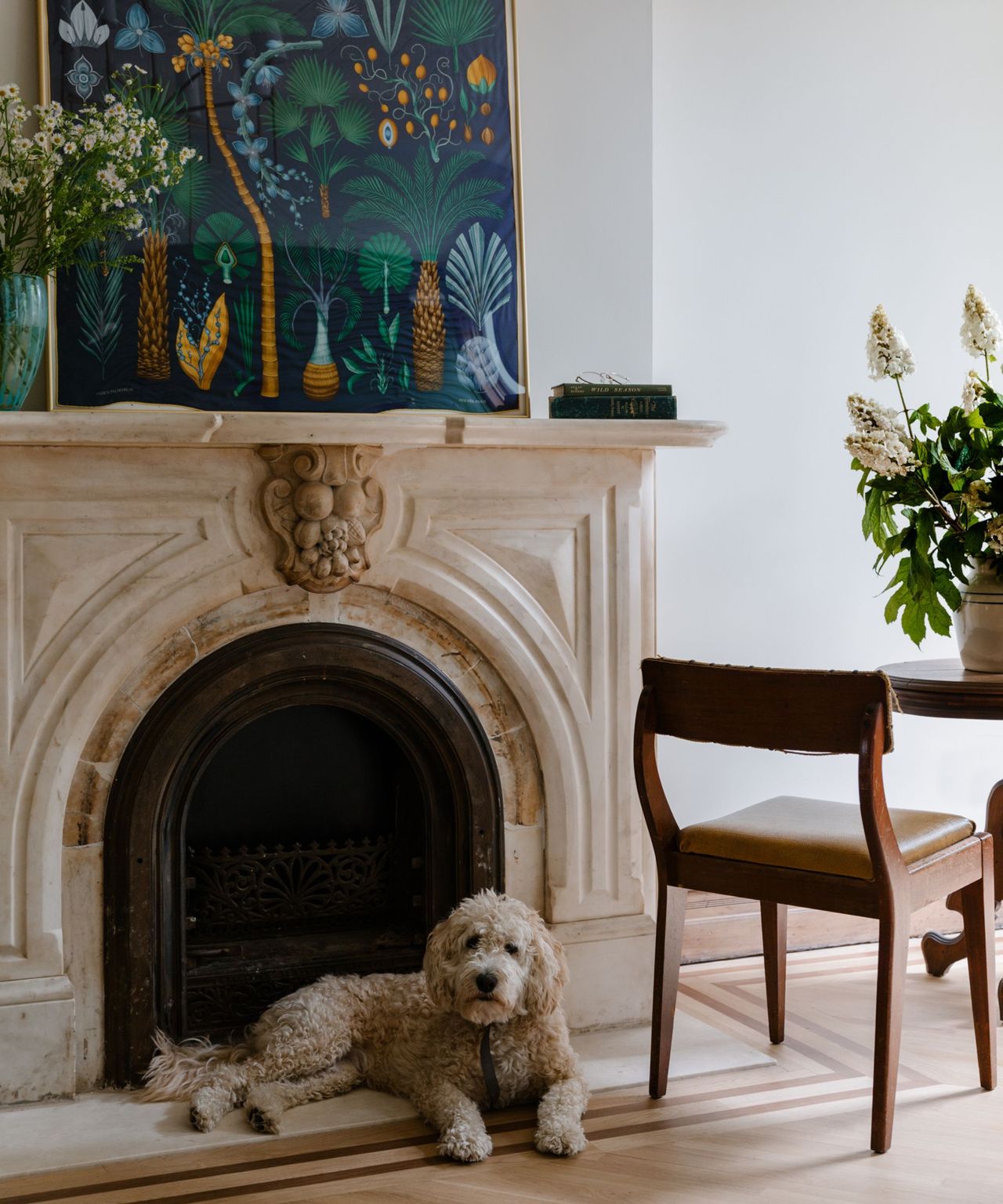 A brownstone living room with a molded fireplace and a dog