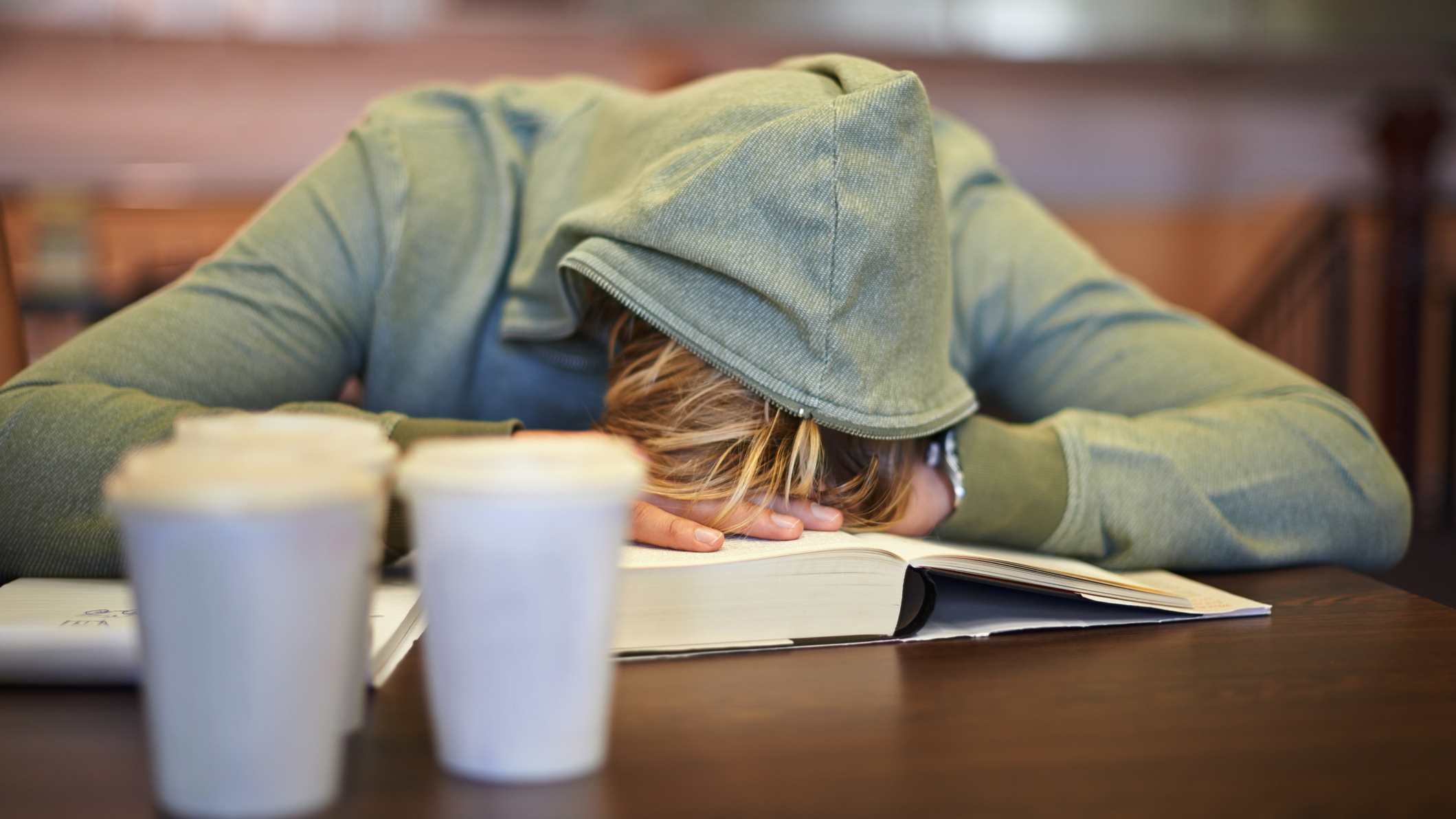 College student wearing a grey hoodie falls asleep in class