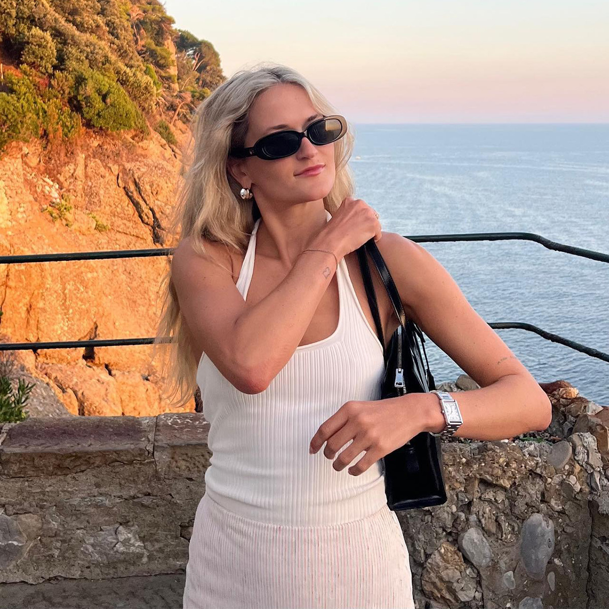 Eliza Huber in Portofino, Italy wearing a white halter top and striped skirt. 