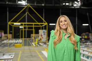 Stacey Solomon standing in a warehouse wearing a green top for Sort Your Life Out season 2