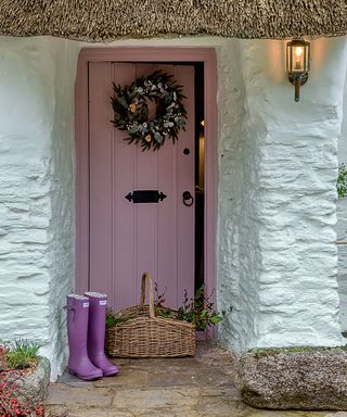 pink door with wreath and wellington boots