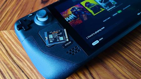 WD Black SN770M SSD on top of Steam Deck LCD sitting on a woodgrain table.