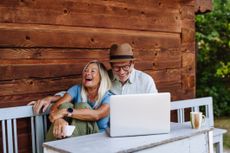 A couple enjoying coffee, looking at a laptop