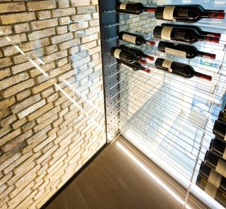 The most apparent and elaborate feature is the transparent wine cellar, suspended from the ceiling vault in a corridor of glass