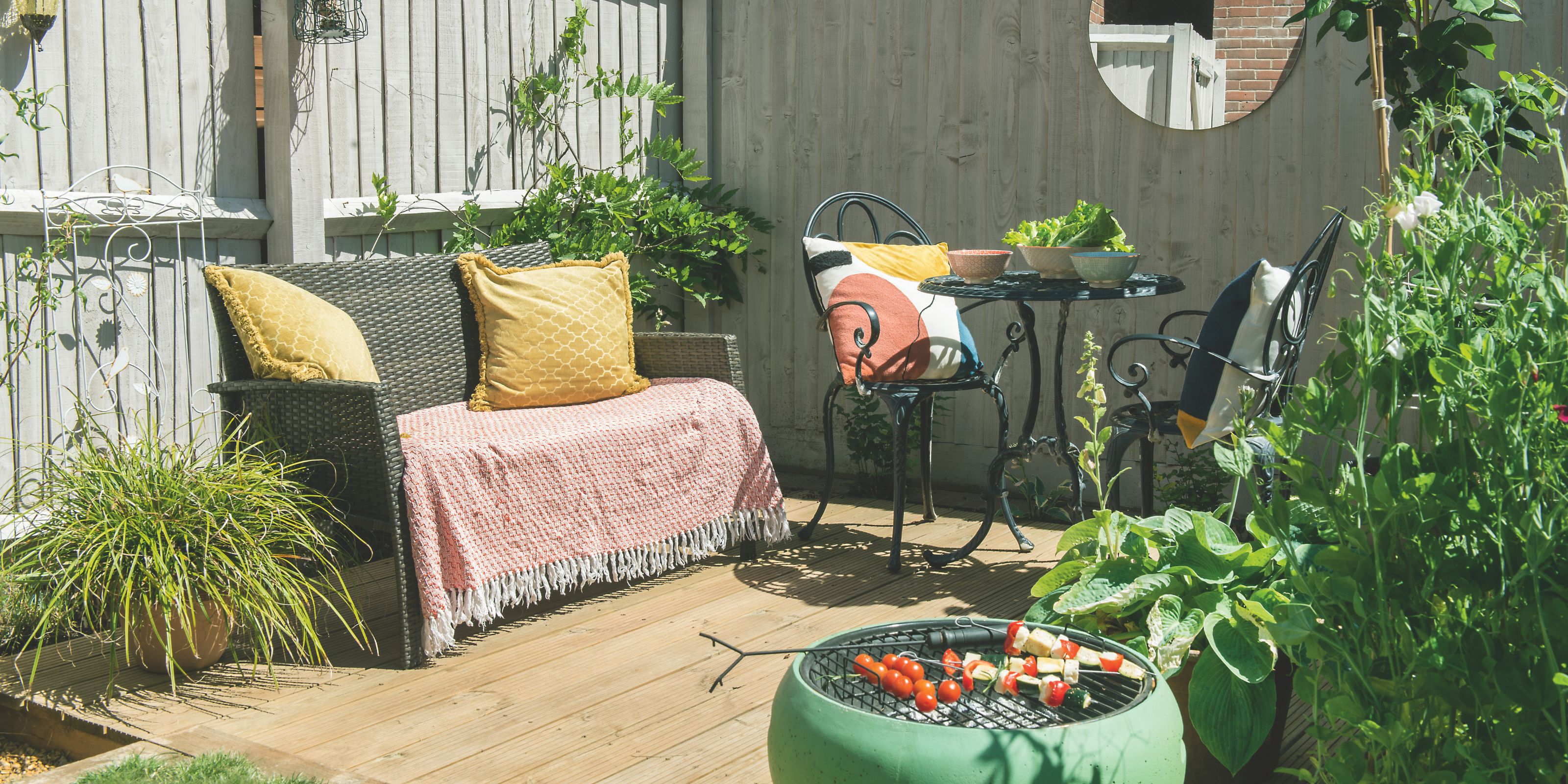 Small garden with wood decking, a garden sofa and small bistro set