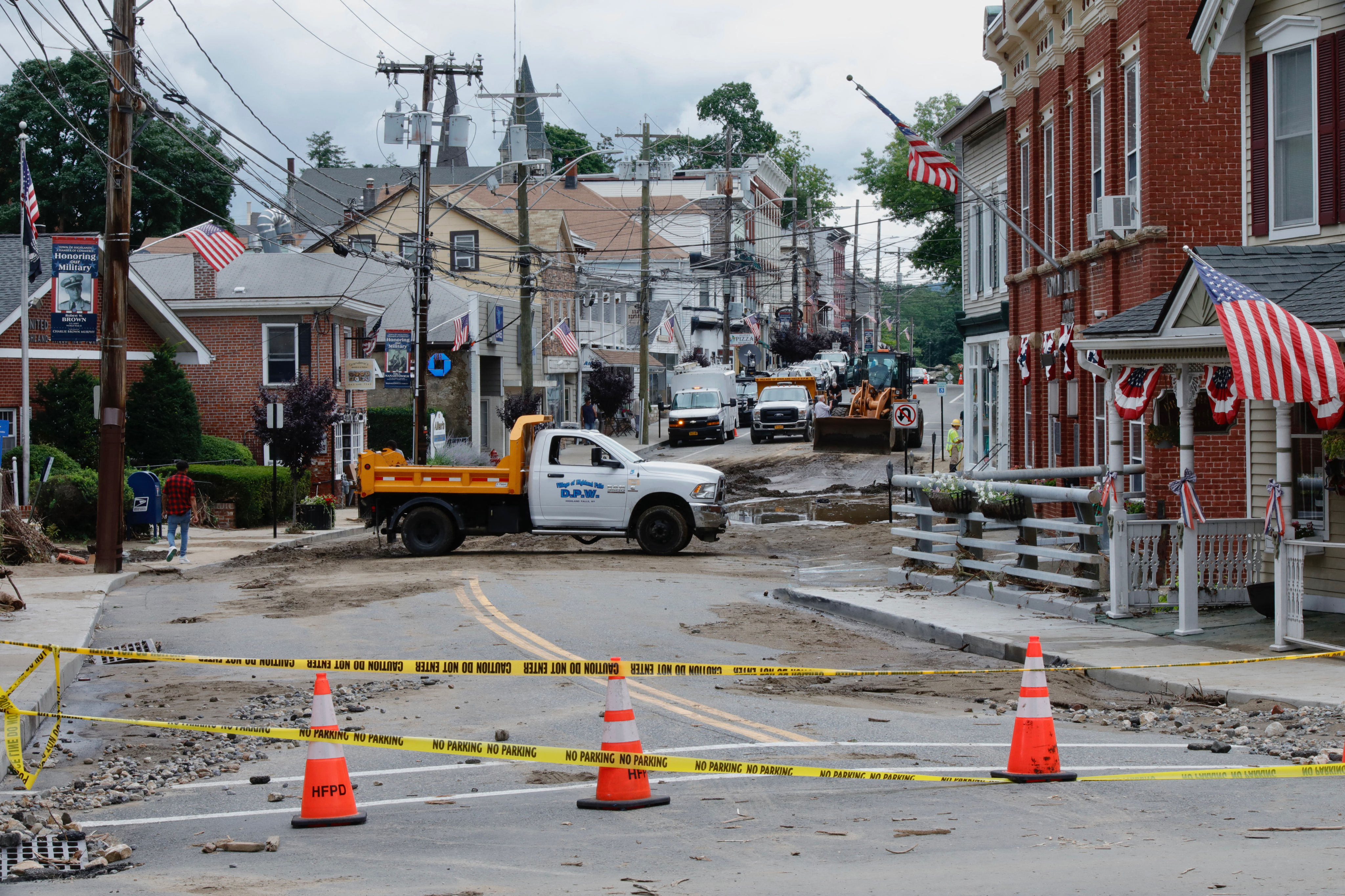 a town in new york state damaged after flash floods with police tape cutting off a damaged area