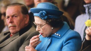 Queen Elizabeth applying lipstick